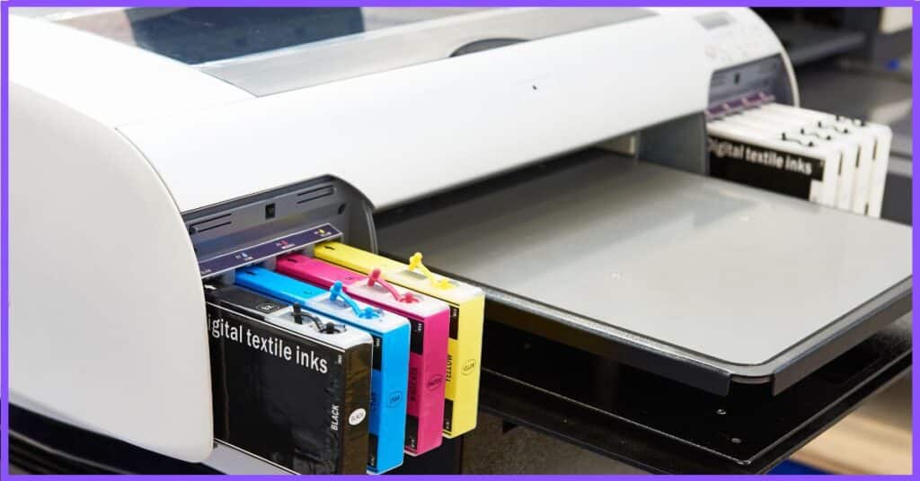 A large format printer with a set of black digital textile ink cartridges in cyan, magenta, yellow, and black.