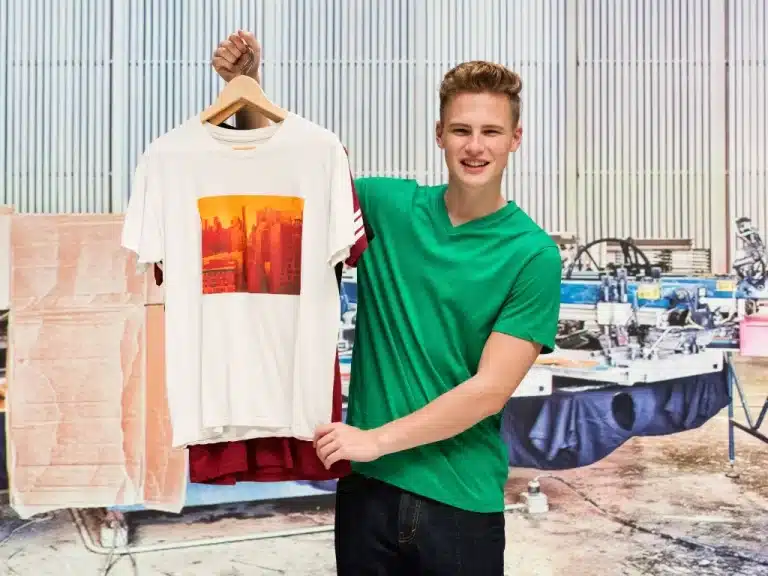 A young boy wearing green shirt and showing the white sublimated shirt