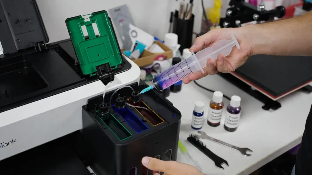 Flushing sublimation printer ink system using cleaning solution to remove old sublimation ink before switching brands.